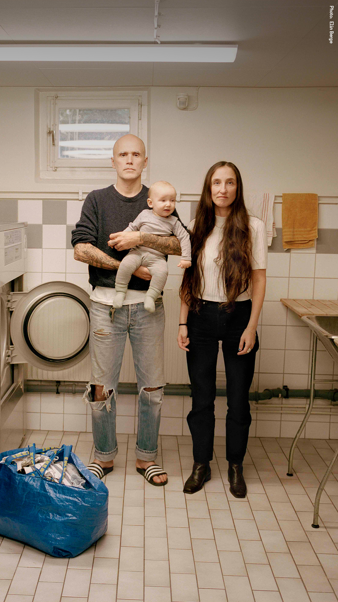 Two parents with their baby in the laundry room