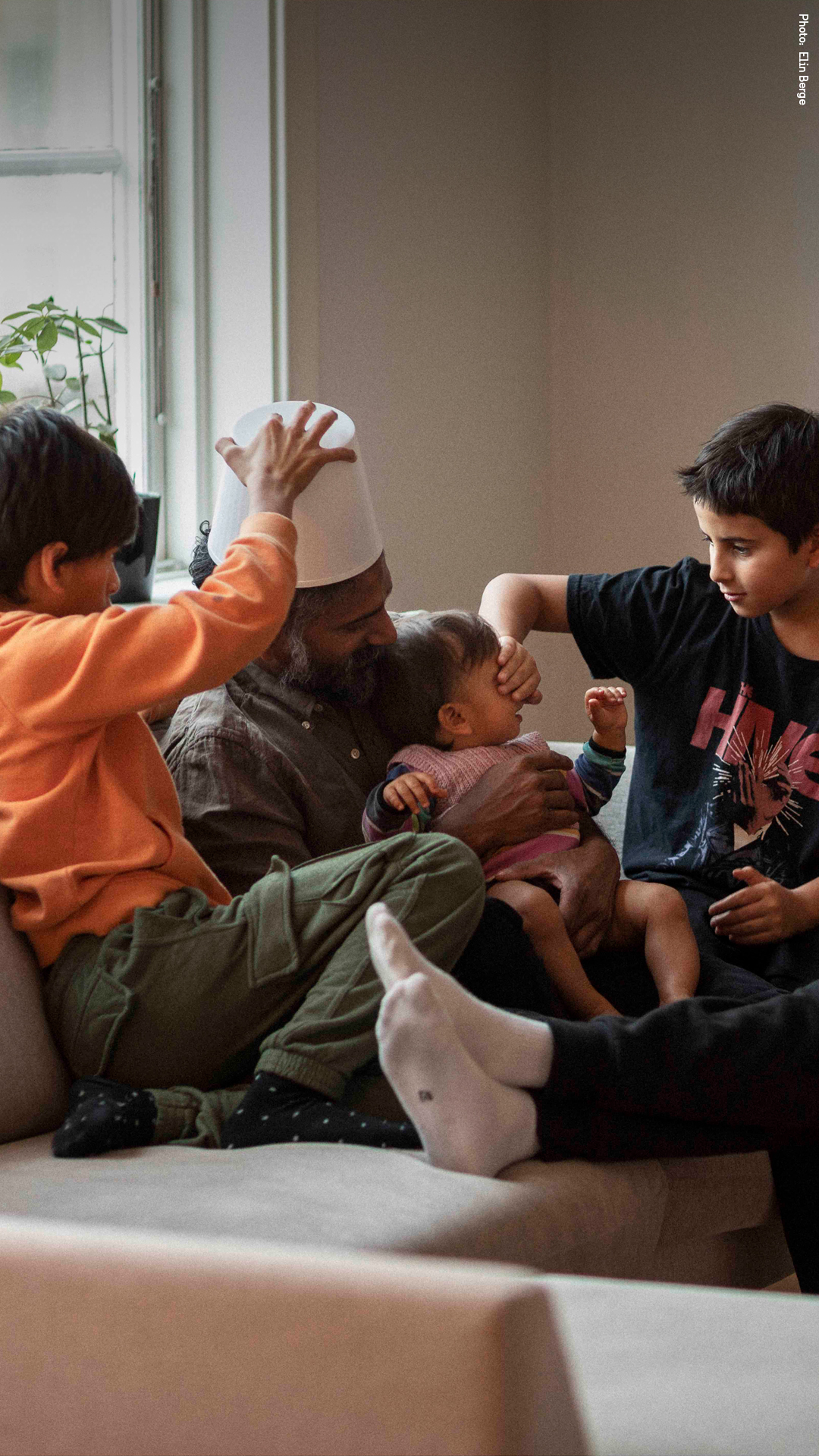 A father and his older children playing with the baby sibling.