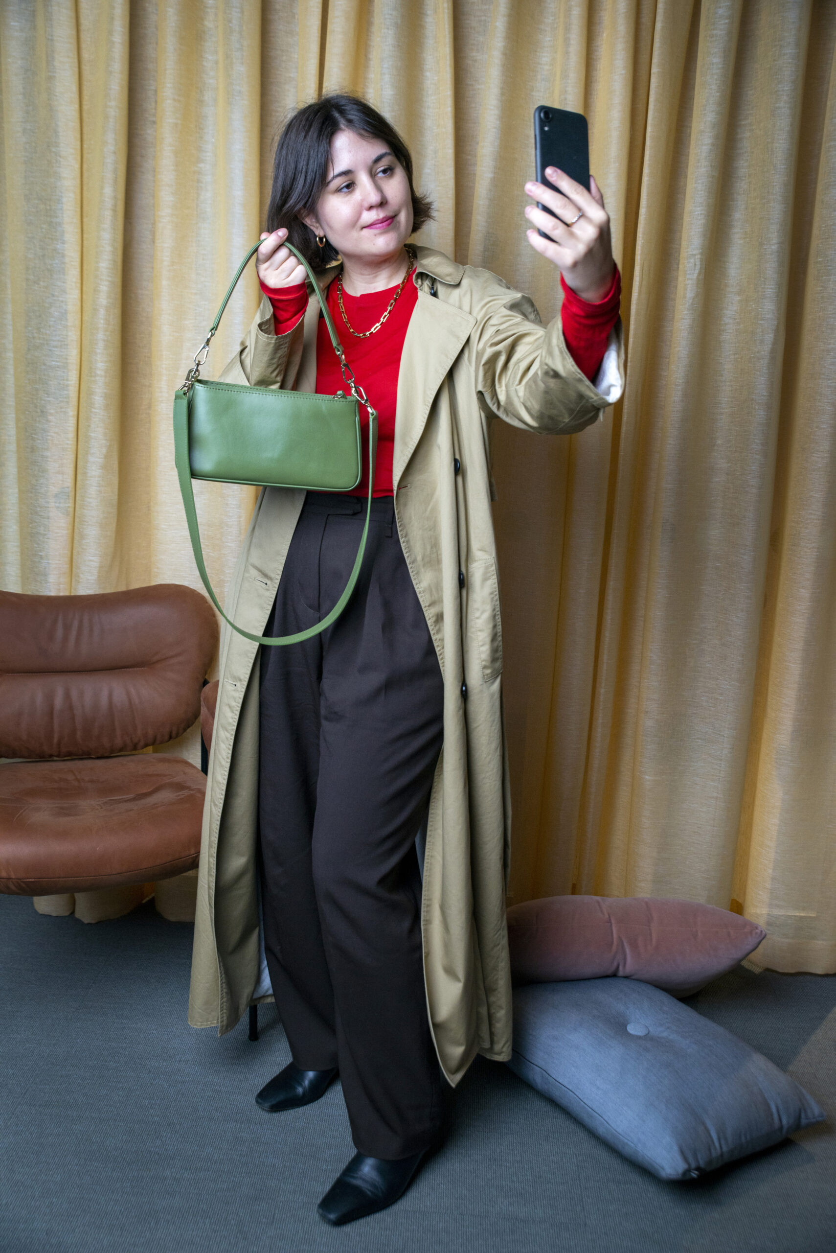 A woman in fashionable clothing taking a selfie.