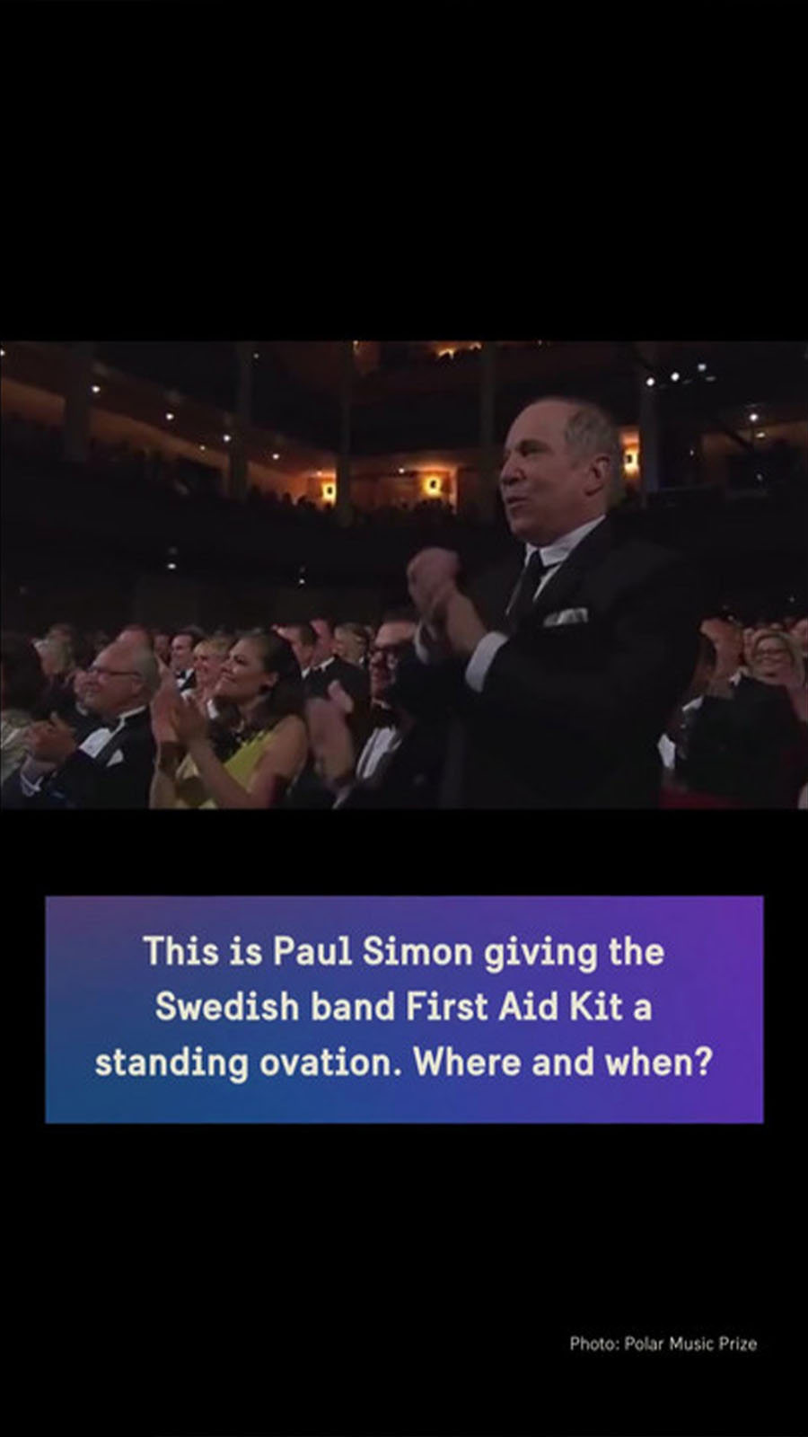 Paul Simon giving a standing ovation as a member of the audience.