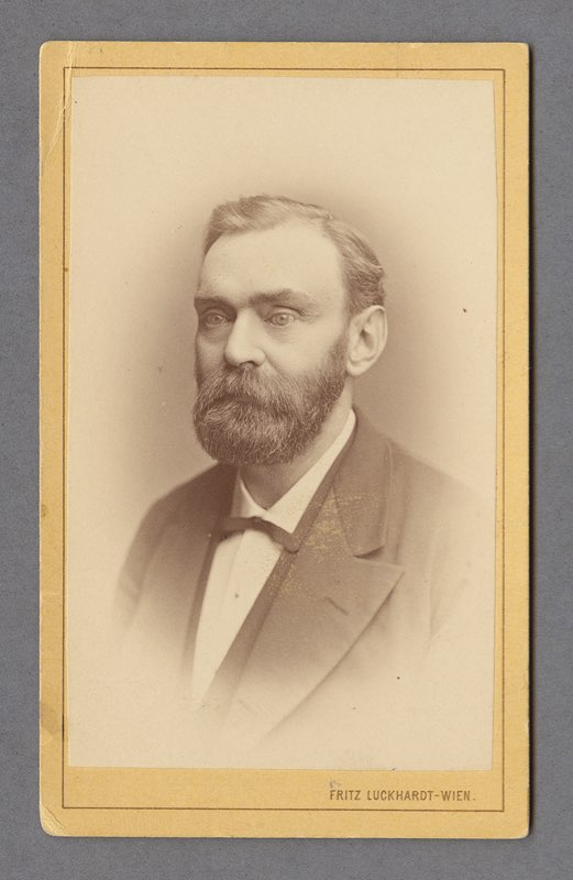 A middle-aged Alfred Nobel with a full beard and suit