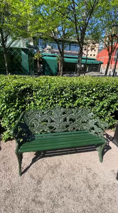 A green bench in a green park