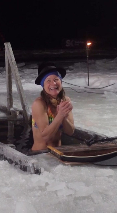 A happy woman in an ice hole.