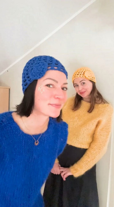 Two women wearing crochet hats.