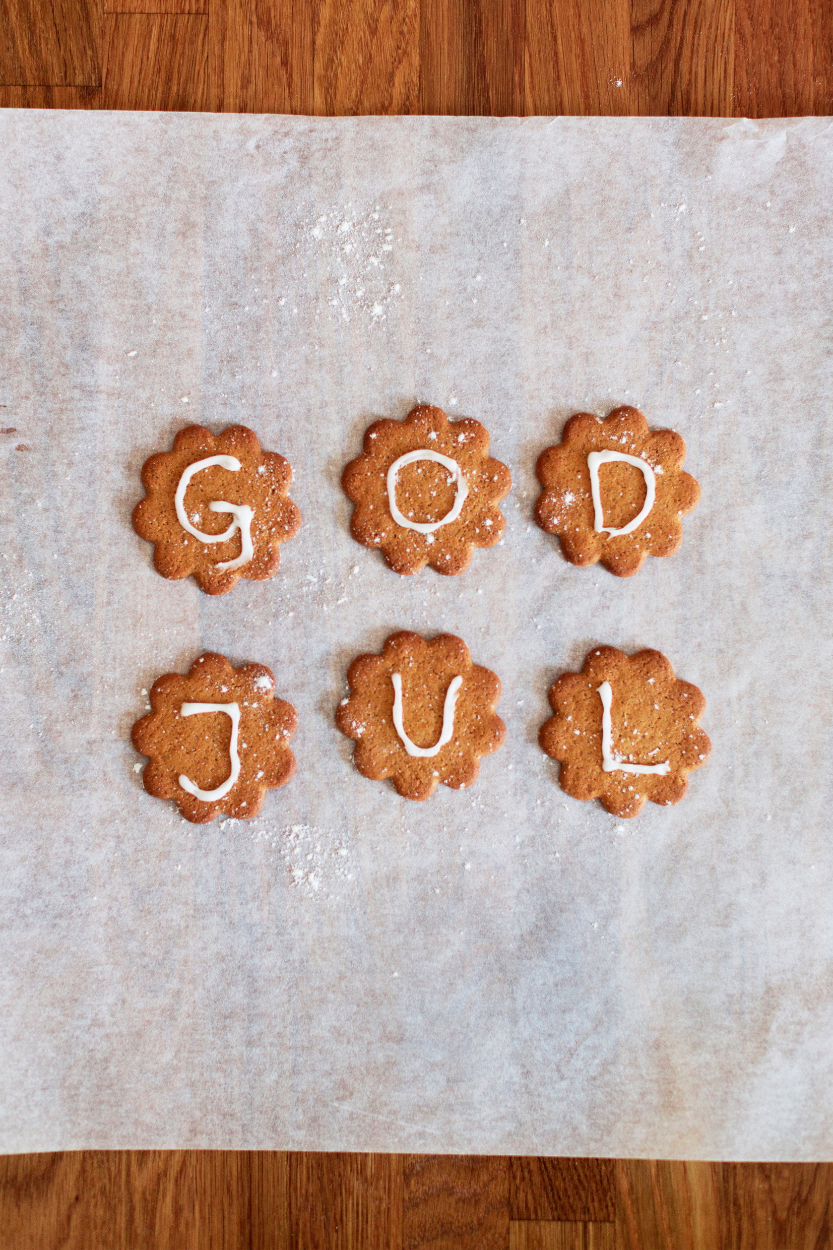 Gingerbread cookies with frosting that spell out god jul, merry Christmas in Swedish.