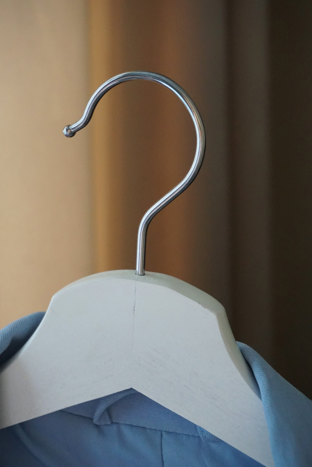 The metal hook of a coat hanger.